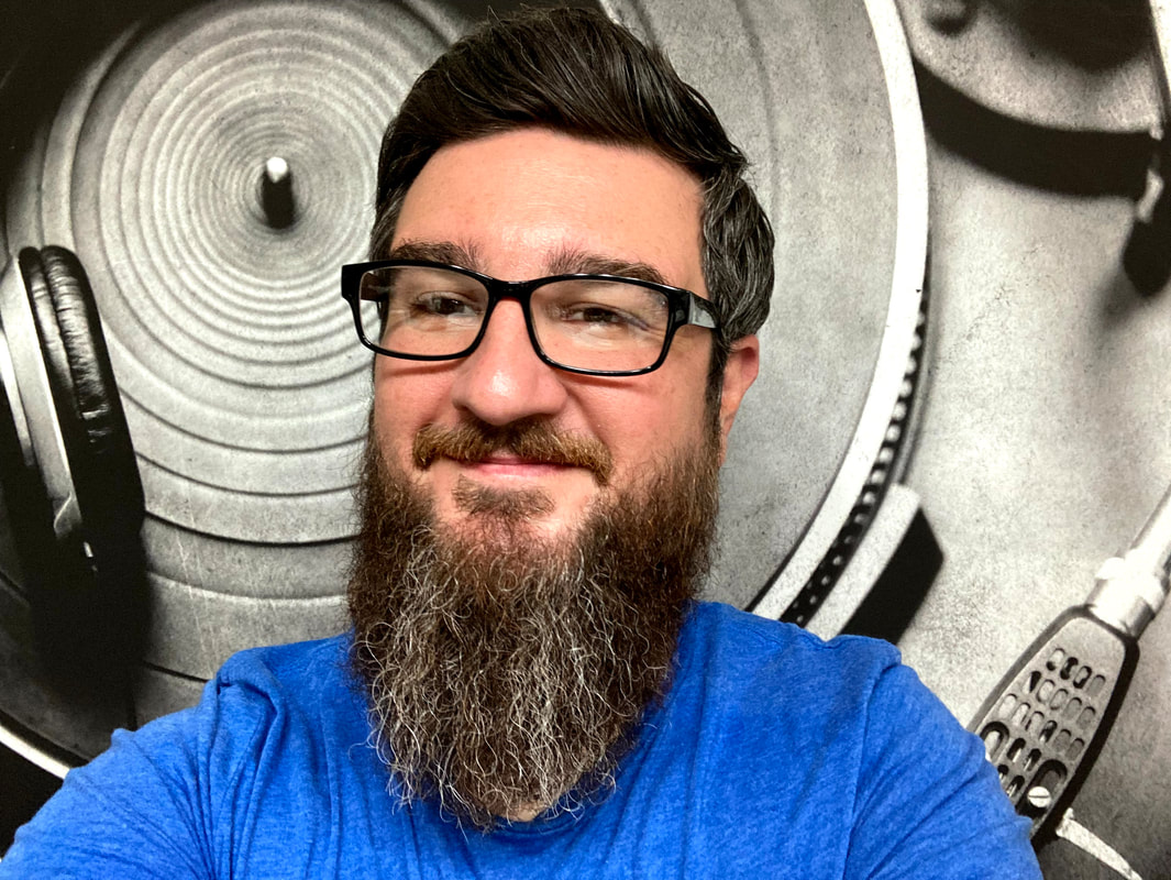 photo of Jonathan Bristow, man in blue shirt with glasses and a beard