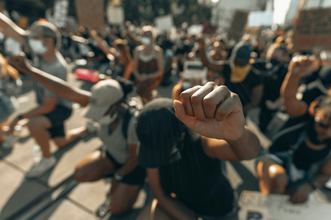 crowd kneeling with fists in air